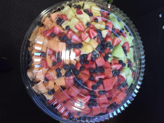 Large platter of sliced up fresh fruit.