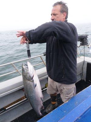 Captain Jeff weighing a King Salmon caught on Fish On Charters.