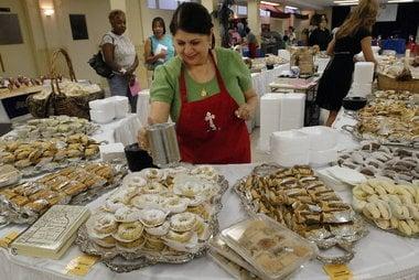 Volunteer sprinkle sugar over pastries.