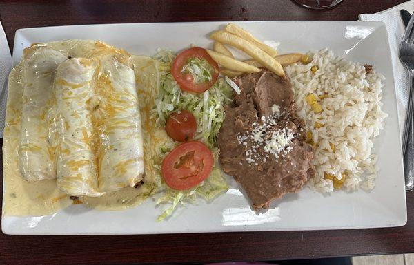 Beef enchiladas with white cheese sauce, rice, and beans. French fries were shared with me