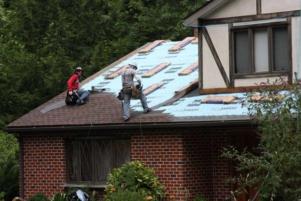 Installing shingles to roof deck.