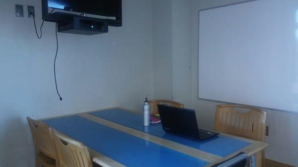 Study room has 1 table, 4 chairs, tv, and a white board.