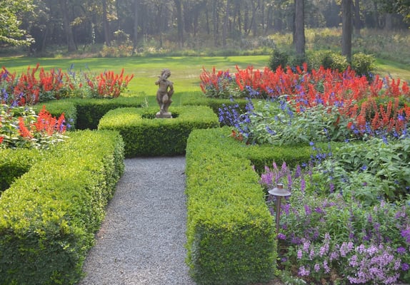 This formal garden is complete with its crushed bluestone path and manicured boxwood hedge. Details are fundamental.