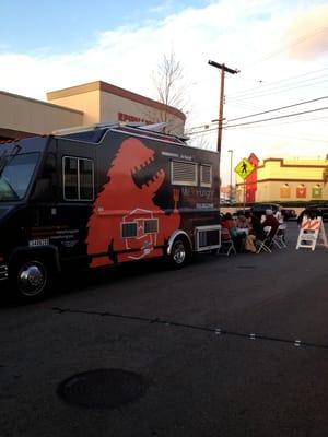 Picnic tables set up around the trucks provide seating