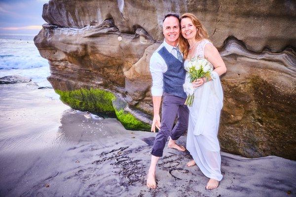 Newlyweds writing in the sand.