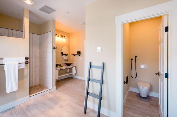 A view of the bathroom of a typical suite. The bathroom looks out into a private garden with a second, outdoor hot water shower!