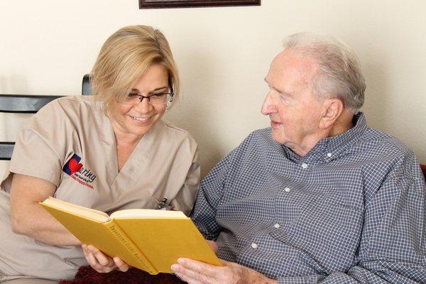 Caring Senior Services caregiver reading with a client