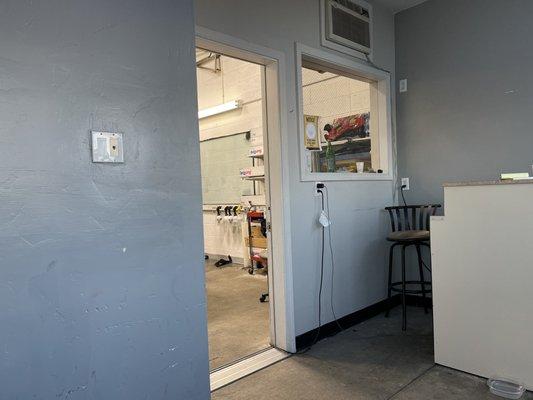 Inside small waiting area looking towards the window tint garage bay.