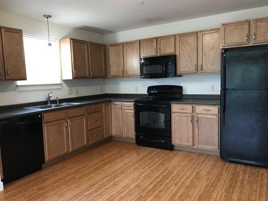 Kitchen with full range, dishwasher, and plenty of cabinet space in 2nd floor unit.