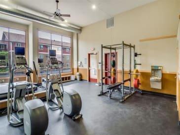 The gym with weights and equipment in a room with windows