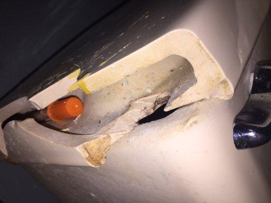 Another angle of the syringe in the broken toilet lid