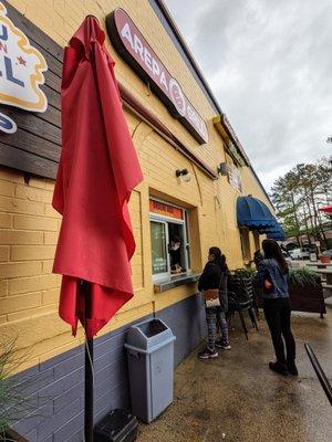 Outside ordering window. Located on the northwest corner of Plaza Fiesta. Exterior storefront.