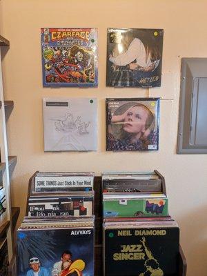 Picture of vinyl records, both on the wall and sitting in a rack