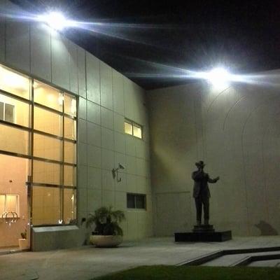 The statue of the late singer, Adan "Chalino" Sanchez outside of the studio building at night.