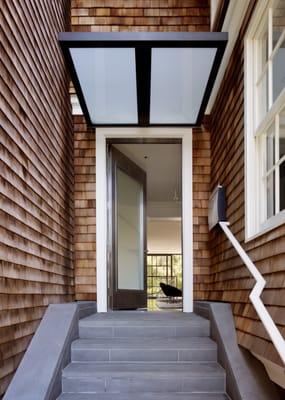 Custom Bluestone entry and awning with a Neoporte Contemporary front door system by Dijeau Poage Construction