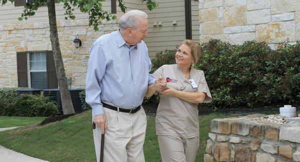 Caregiver and Senior walking into home.