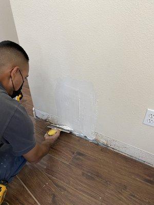 Antonio patching up the dry wall from the leak and subterranean termite damages.