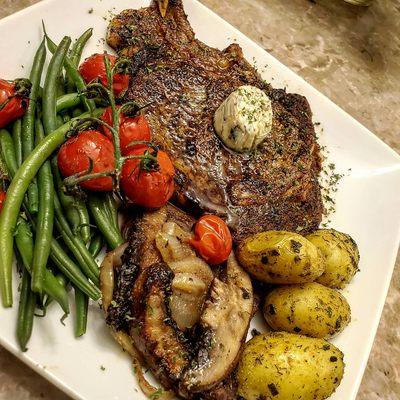 Ribeye Steak with anchovy butter veggies and potatoes.