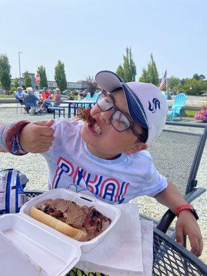 The boy enjoying his beef brisket sammy!