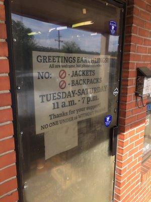 Sign on front door with hours and no jacket/bag rule.