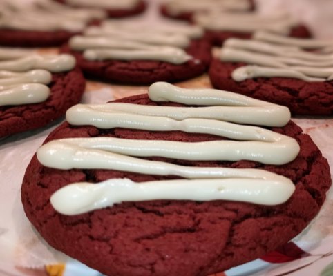 Indulge in the rich and smooth texture of red velvet cookies, adorned with a decadent cream cheese topping.