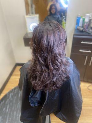 Sleek blowout on natural curly hair with a shag cut