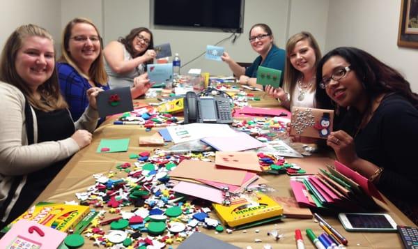 Employees making holiday cards for veterans.