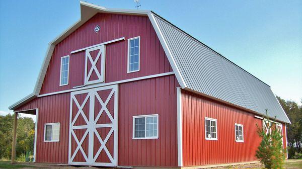 This Post Frame Agricultural Barn built by Structural Buildings features a flying gable, a hay door, a gambrel roof, and dutch doors.