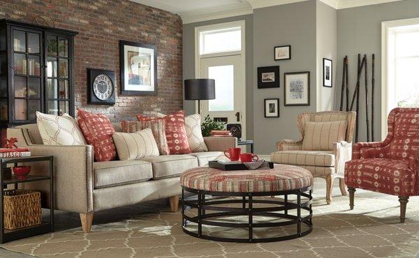 Sofa with contrasting throw pillows, upholstered ottoman & wood framed accent chair.