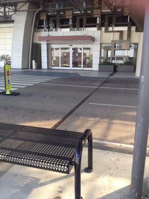 Exit by Armstrong sculpture near Airport Passenger Relations desk and stage. E2 sign on cement pillar across driveway.