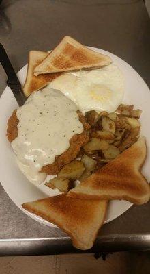 Country fried steak with eggs and potatoes