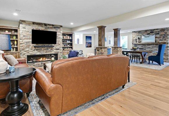 Warm & cozy living/dining area with gas fireplace, natural stone accents, mixed wood & metal tones.