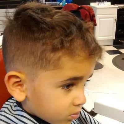 Lil guy fade on the sides , curly on top