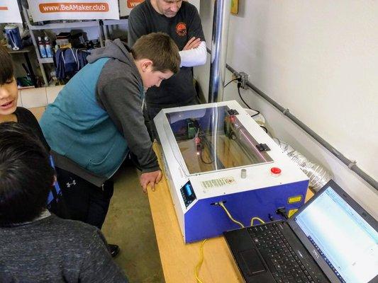 Children working on the Laser Engraver and Cutter