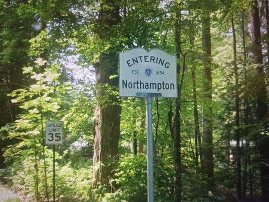 Entering Northampton on North Farms Road. The sign has nothing behind it, but on the other side of the road is an entering Williamsburg sign