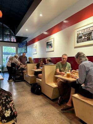 Tables for two right by the wall where they had pictures of Pizza places in New York City.