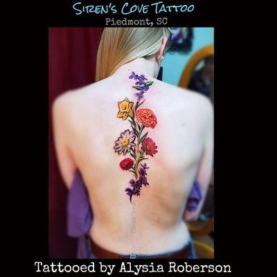 Flowers along a scar she has up her back! Tattooed by Alysia Roberson at Siren's Cove Tattoo in Piedmont ,SC!