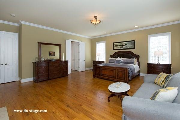 'After' of Occupied Staging of Master bedroom by DO STAGE LLC. We removed the dark rug, curtains. Slip cover on sofa, new bed linen - Voila!