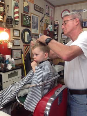 Joseph D. giving a haircut to a young man.