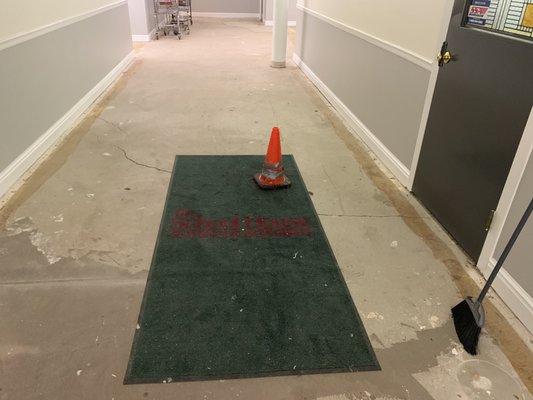 The road cone that has been in the hall for months after an elderly resident was injured tripping on the crack in the floor.