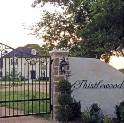 Custom metal gate, stone, stucco and signs