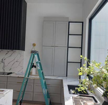 Black trim painted on the custom shelving, adding a sleek, sophisticated touch.