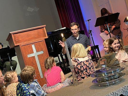 Young disciples get a special time at the front with Pastor Blaise before heading to Kids Worship.