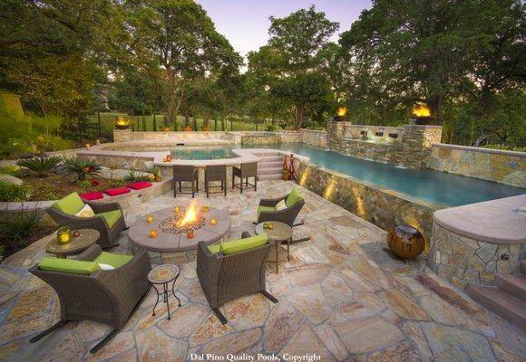 A backyard retreat with privacy created by raised fire and water features. natural stone adds beauty and durability for endless enjoyment.