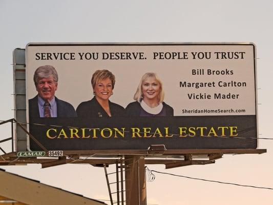 The new Carlton Real Estate billboard says it all! Service you deserve. People you trust. See it for yourself, located off of Coffeen Ave.