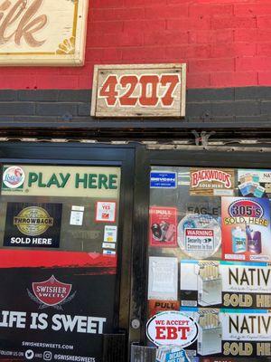 Front door covered in tacky stickers so you can't see inside the store.