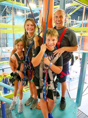 A family enjoying the Sky Trail adventure ropes course together.