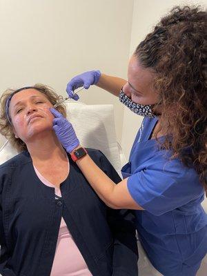 Dr. Mundi administering filler to a client