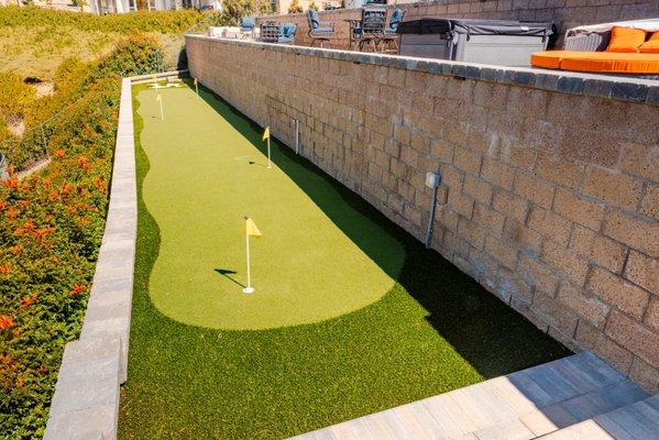 Custom synthetic grass putting green with sand trap.