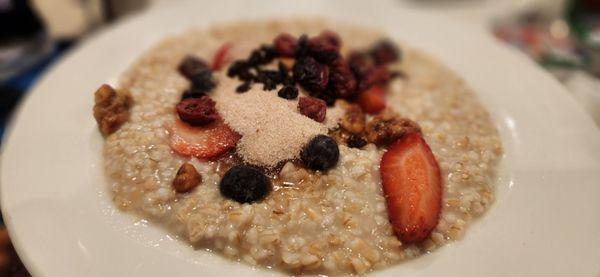 Oatmeal with candied pecans, brown sugar, strawberry and blueberries